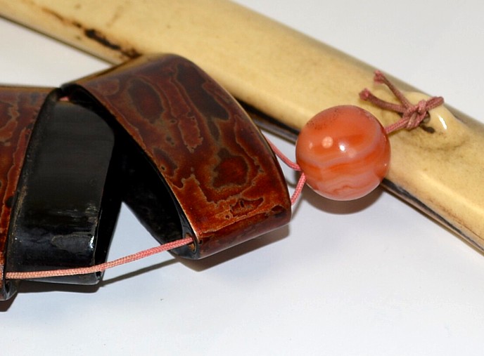 japanese antique smoking set details: round netsuke, pipe's case and tobacco poach